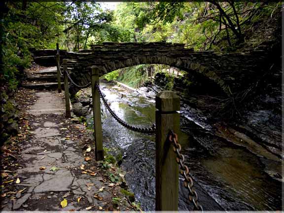 A stone bridge archng over Cascadilla Gorge.